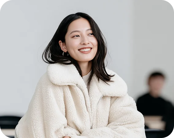 Smiling woman in a cream fleece jacket at a desk